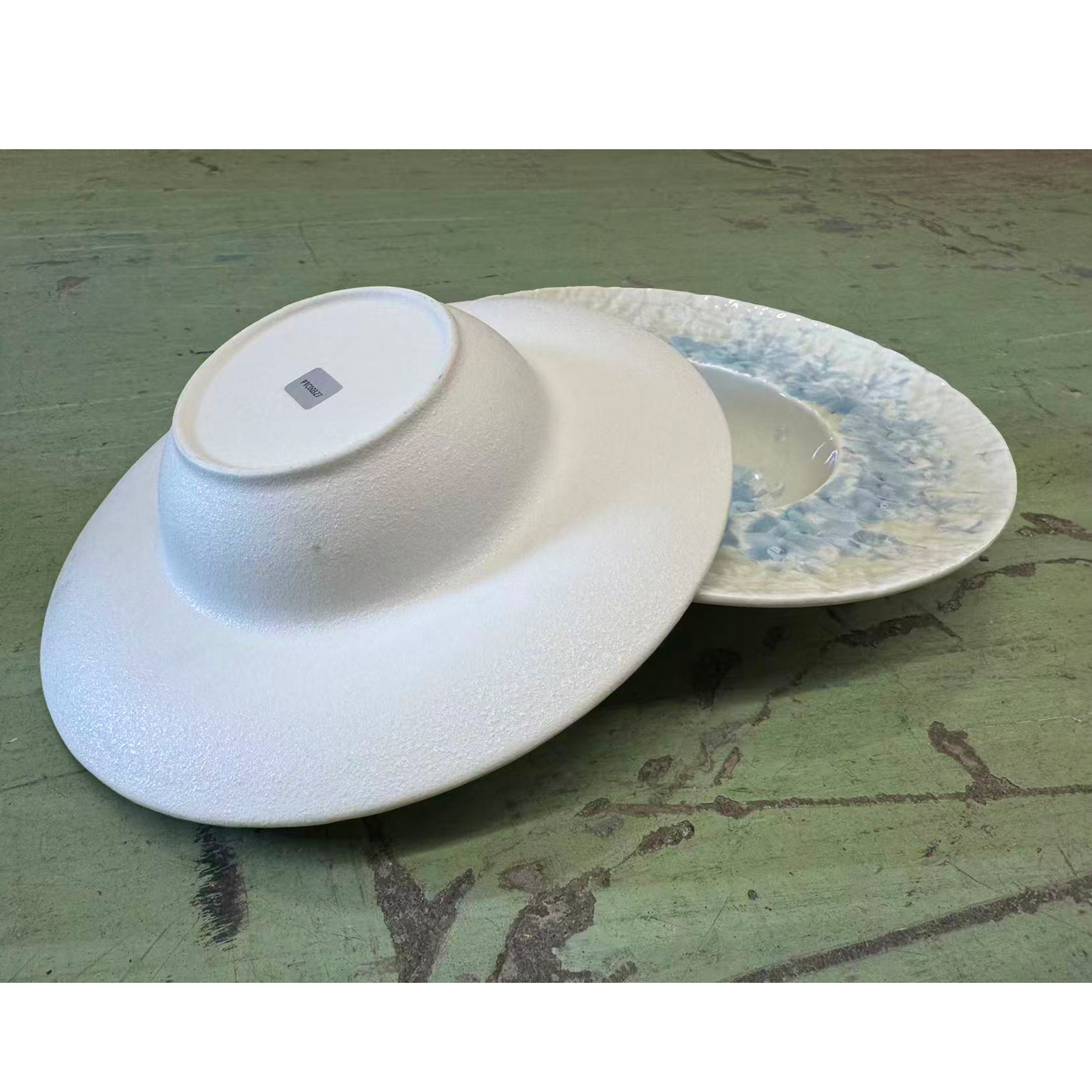 Chefco, 11 " white, textured pasta or soup bowl, with a matching plate featuring a reactive glaze pattern in blue and yellow tones (PTC00327)